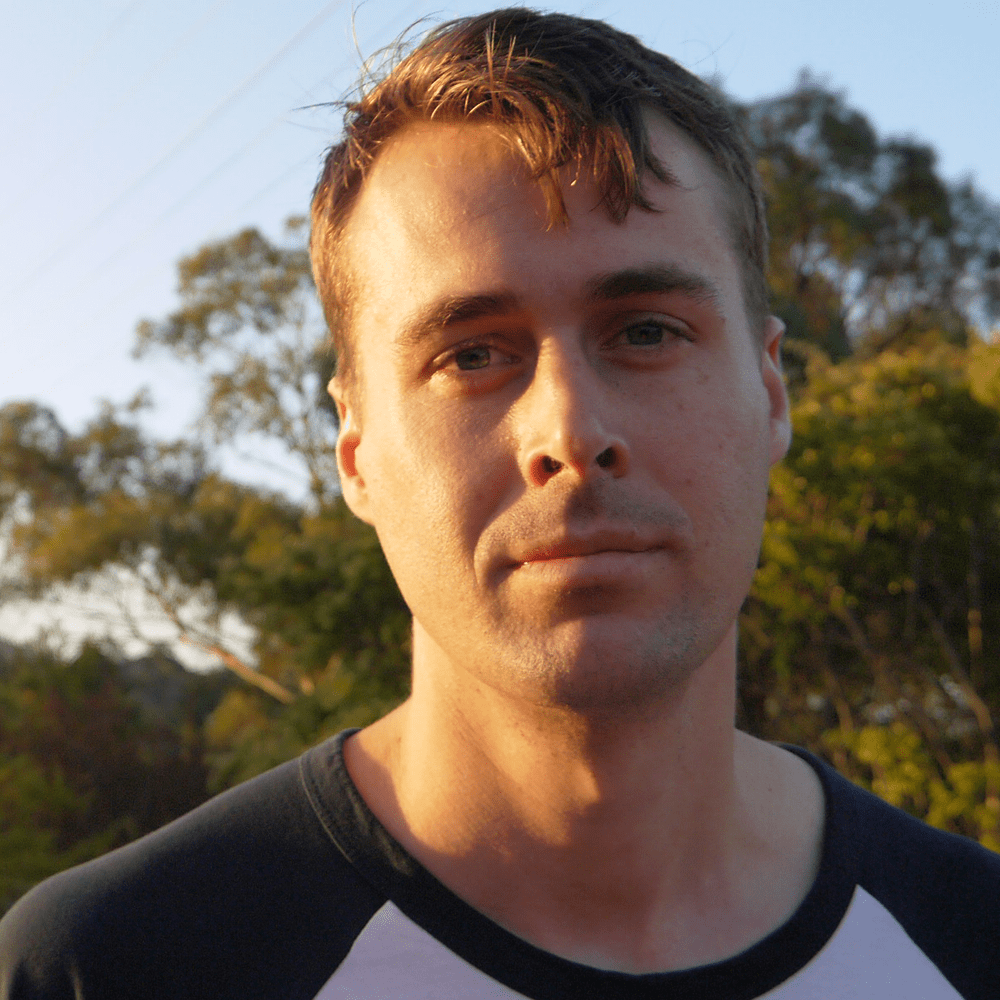 Portrait of a man outdoors with trees in the background, author bio photo