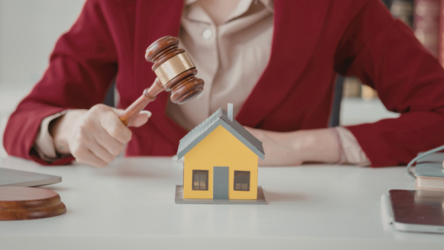 Person in a red blazer holding a gavel