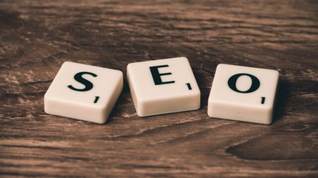 Three Scrabble tiles spelling SEO on a wooden surface, illustrating bad SEO habits and neighbourhood links